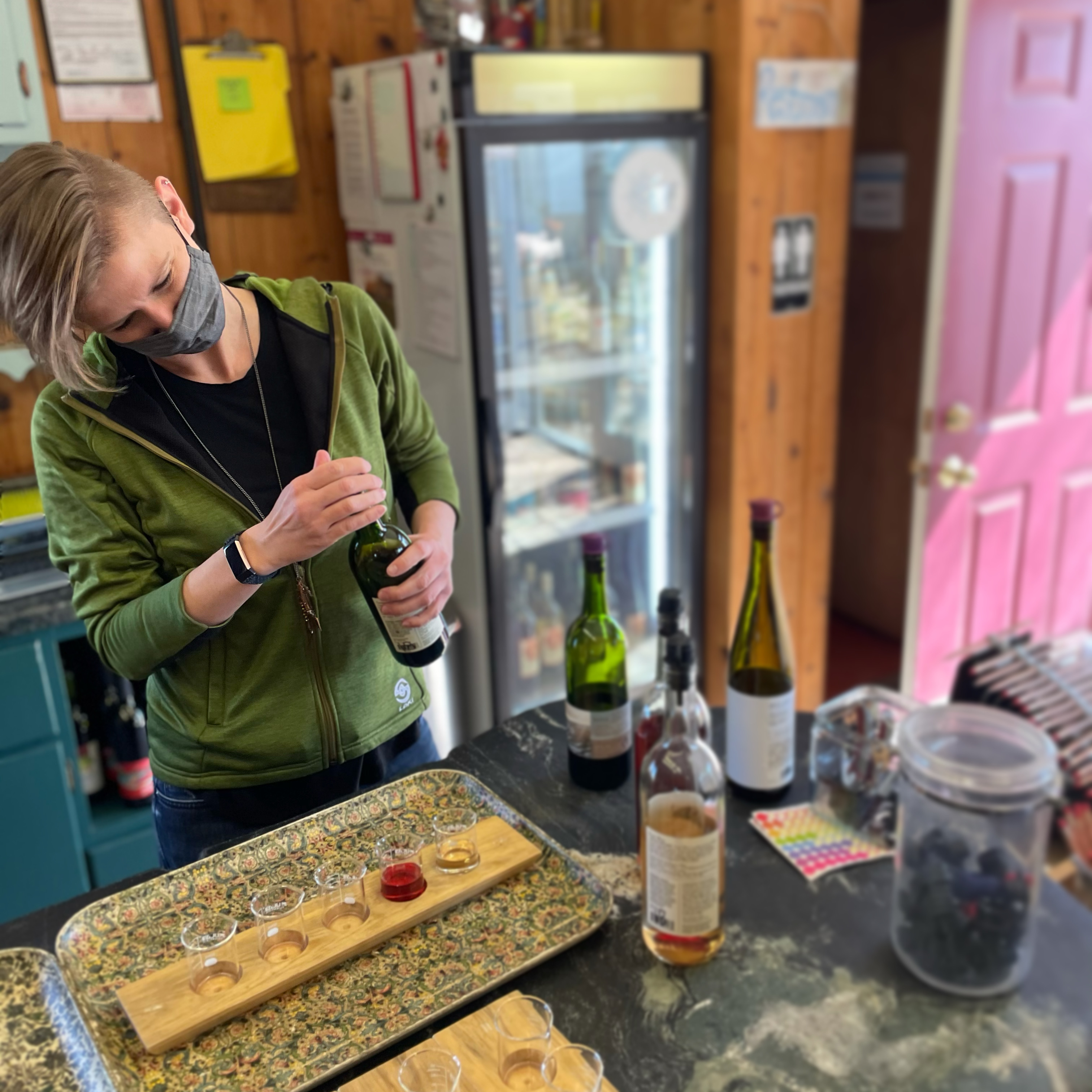 Staff member pouring a flight with a face mask on